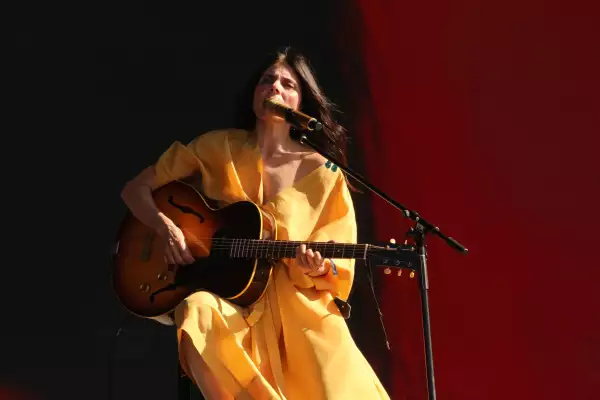Foto de Ely Guerra con un vestido amarillo, sentada, cantando y tocando la guitarra durante el primer Simi Fest.