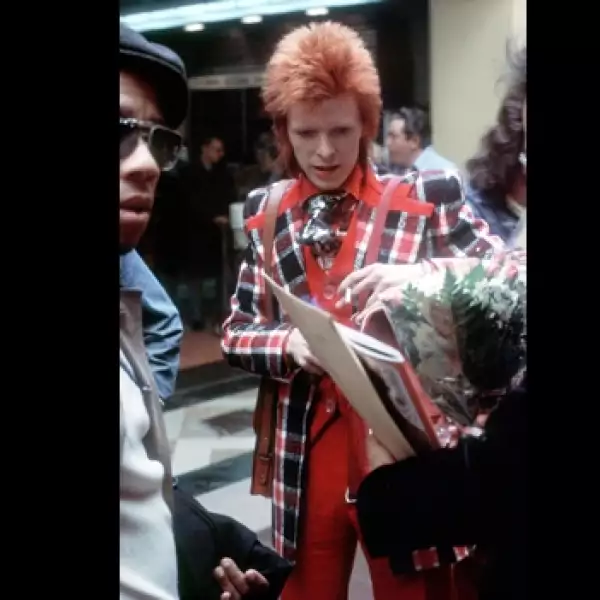 bowie firma un autografo con la mano izquierda en 1973