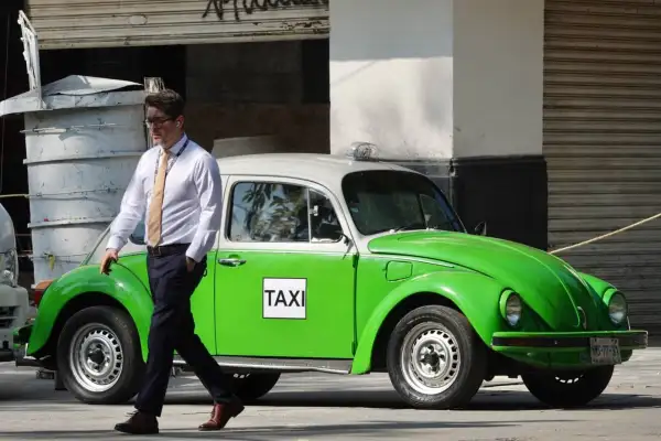 Volkswagen Sedán conocido como Vocho, acondicionado como taxi de la Ciudad de México, con carrocería en color verde y blanco. El automóvil aparece estacionado en una calle de México y conserva el diseño clásico de este modelo.