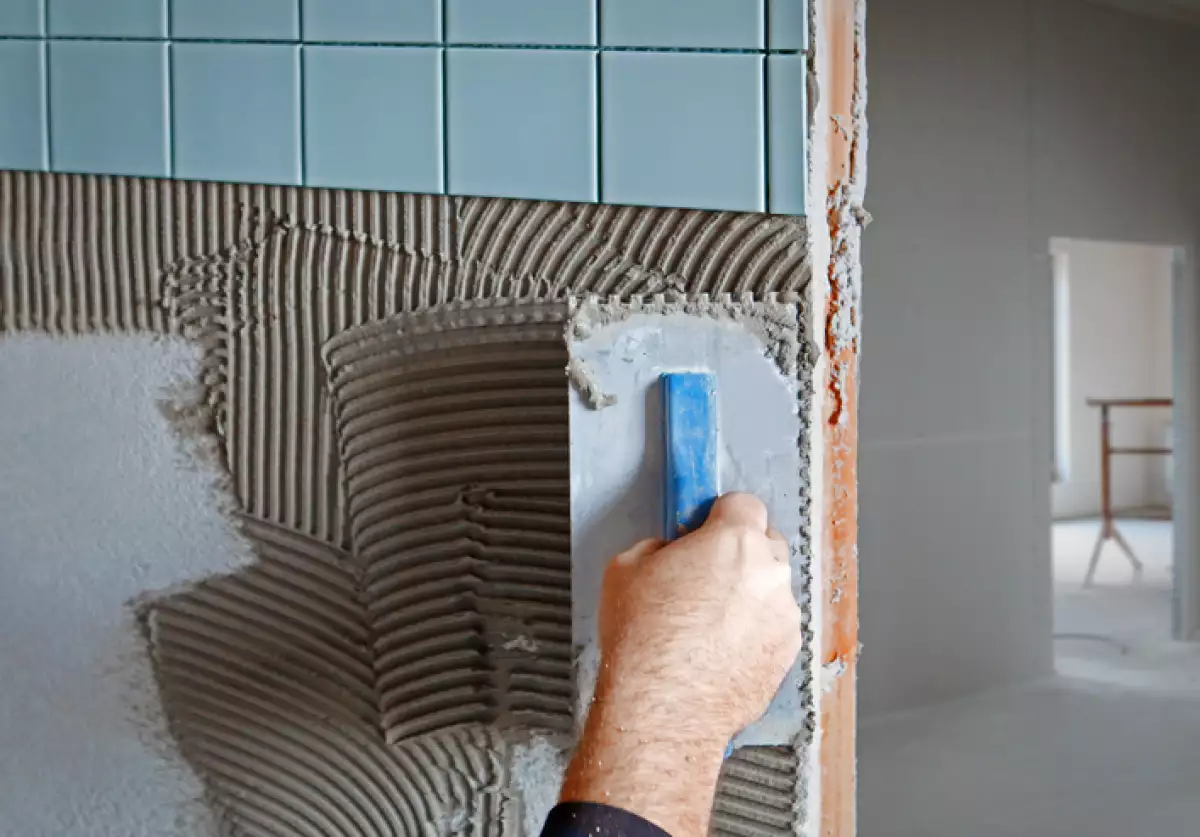Tiler making new facing on the wall