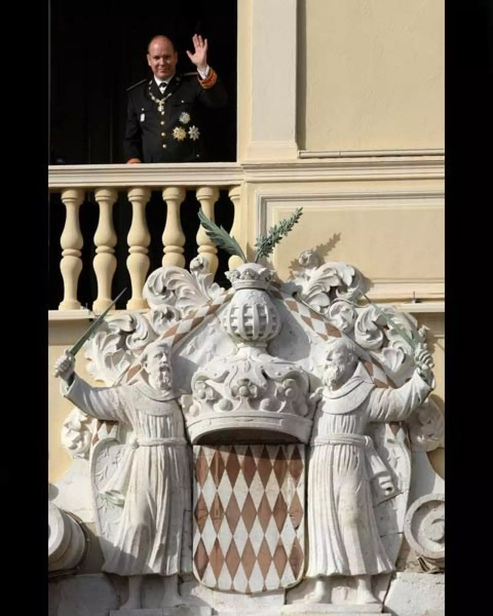 El príncipe Alberto II de Mónaco saluda desde una ventana del Palacio de Mónaco durante la ceremonia.