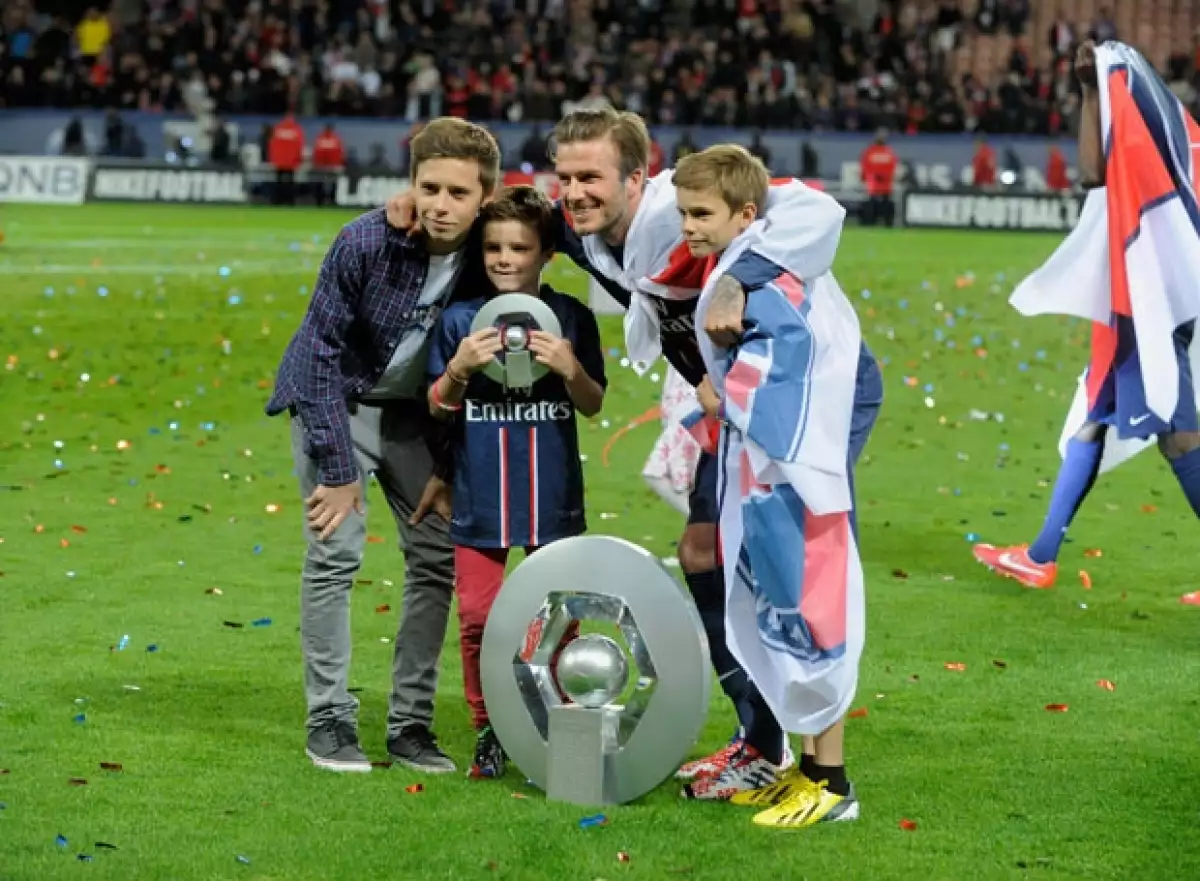 Brooklyn, Cruz y Romeo apoyando a su papá en un partido de futbol en Francia.