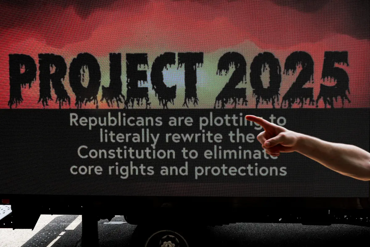 Una persona hace un gesto frente a un cartel que hace referencia al "Proyecto 2025" mientras los manifestantes y miembros de The Coalition to March on the RNC mantienen un mitin, el primer día de la Convención Nacional Republicana (RNC) en Milwaukee, Wisconsin, EE. UU. 15 de julio de 2024.