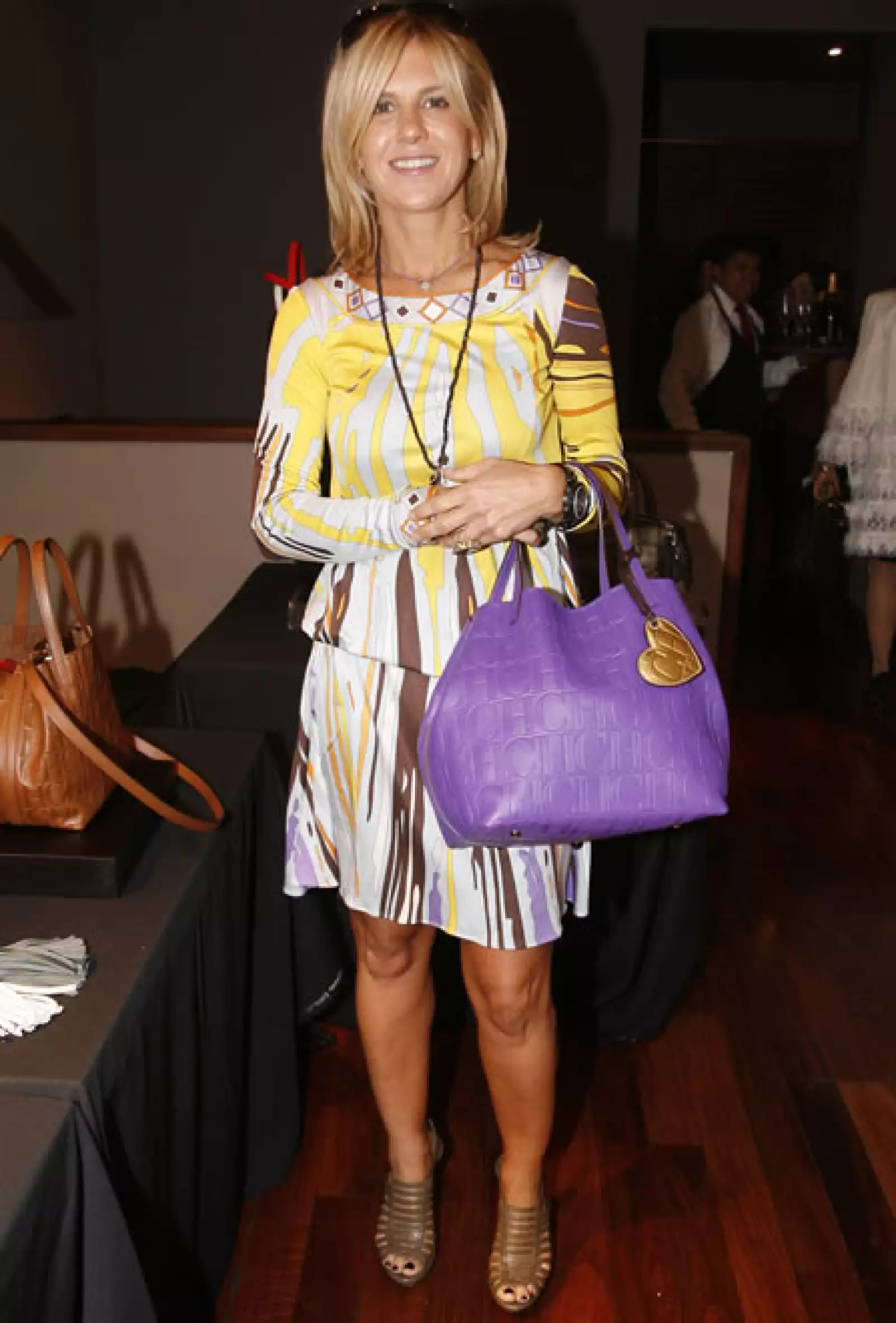 Un look de explosión de color que le favorece su tono de piel y rubia cabellera. El contraste con los tonos ocres y amarillos de su vestido lo hace la maxi bolsa morada.