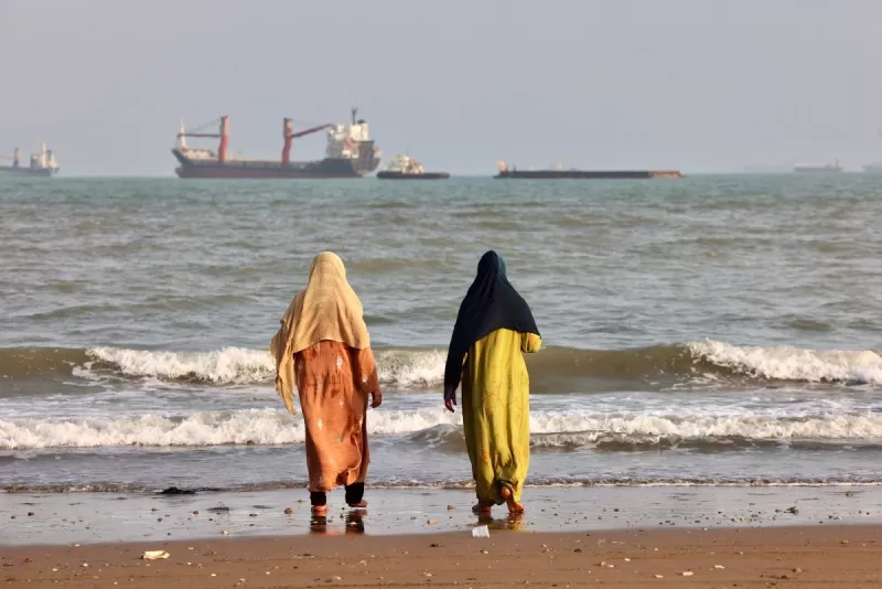 Los iraníes disfrutan de la orilla del mar mientras se ven barcos en el Estrecho de Ormuz frente a Bandar Abbas, en el sur de Irán, el 10 de agosto de 2026.