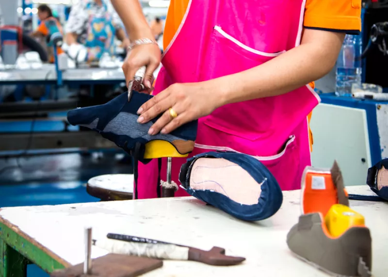 worker making shoe in footwear production line