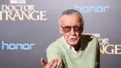 Foto de Stan Lee en octubre de 2016 con lenes oscuros y la mano derecha con el gesto de Spider-Man lanzando su telaraña.