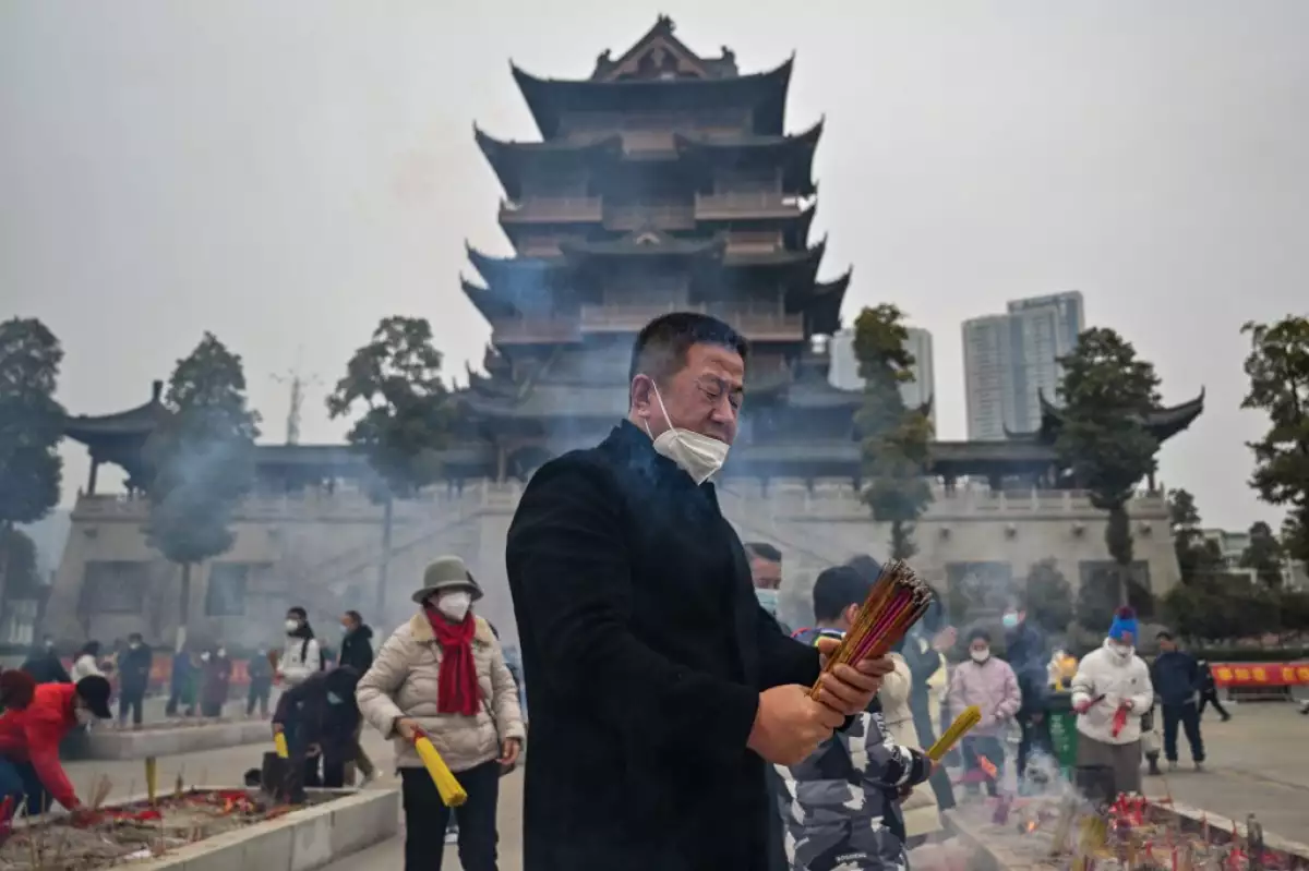 Personas queman varas de incienso en el templo budista de Guiyuan en Wuhan, en la provincia central de Hubei de China. 