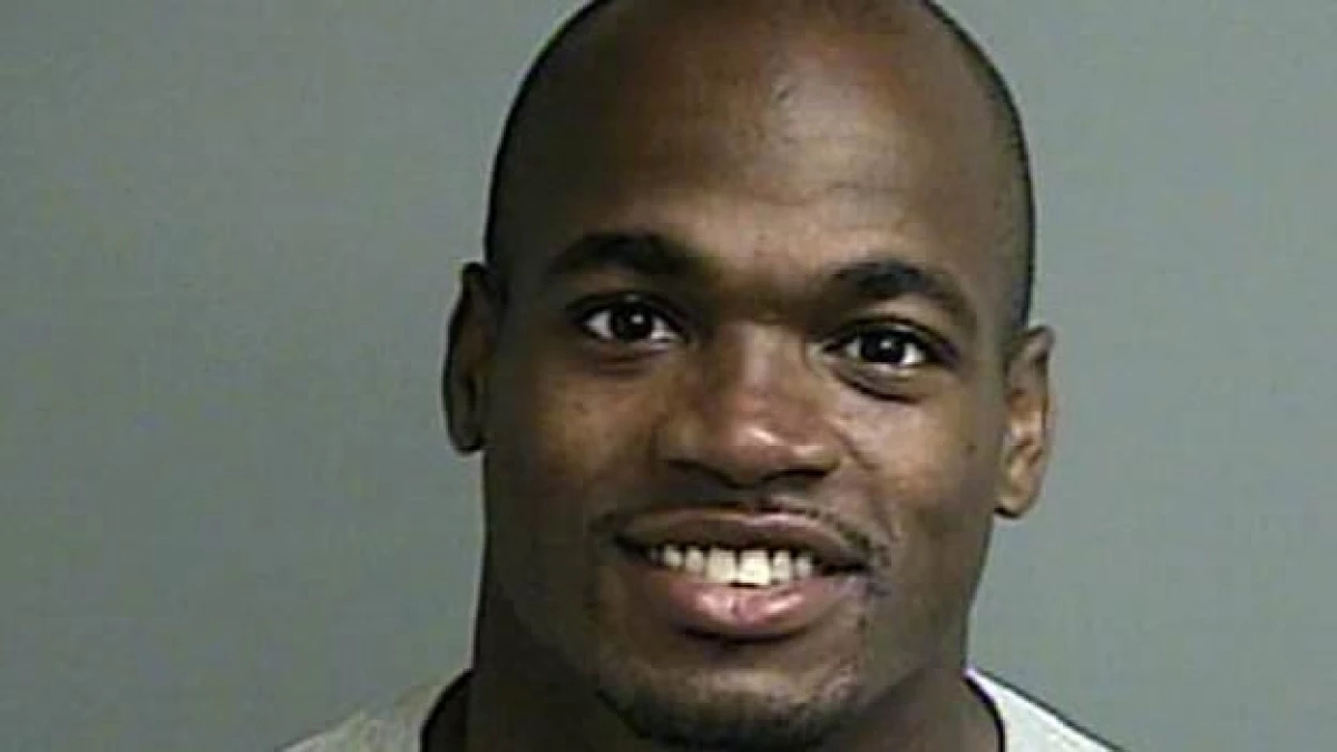 El jugador de la NFL Adrian Peterson aparece sonriendo en la foto que le tomaron tras entregarse a las autoridades