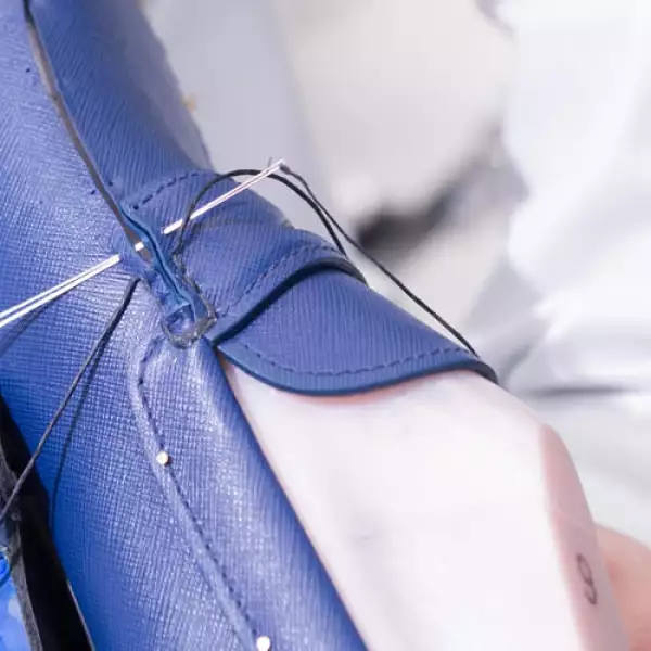 Se necesitan más de 100 dobles puntadas para coser a mano todas las partes de cuero que componen el mocasín. Después, se hacen los agujeros, también a mano.