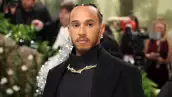 foto de lewis hamilton en la met gala 2024 usando un collar llamativo y aretes de flores
