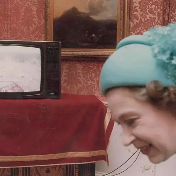 Otra imagen de la reina inglesa viendo al numeroso público afuera del Palacio de Buckingham.