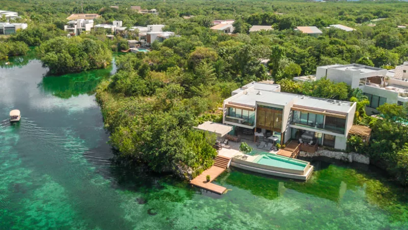 Foto aérea de una habitación del hotel Rosewood Mayakoba en Riviera Maya, en medio de los manglares y frente a una laguna.