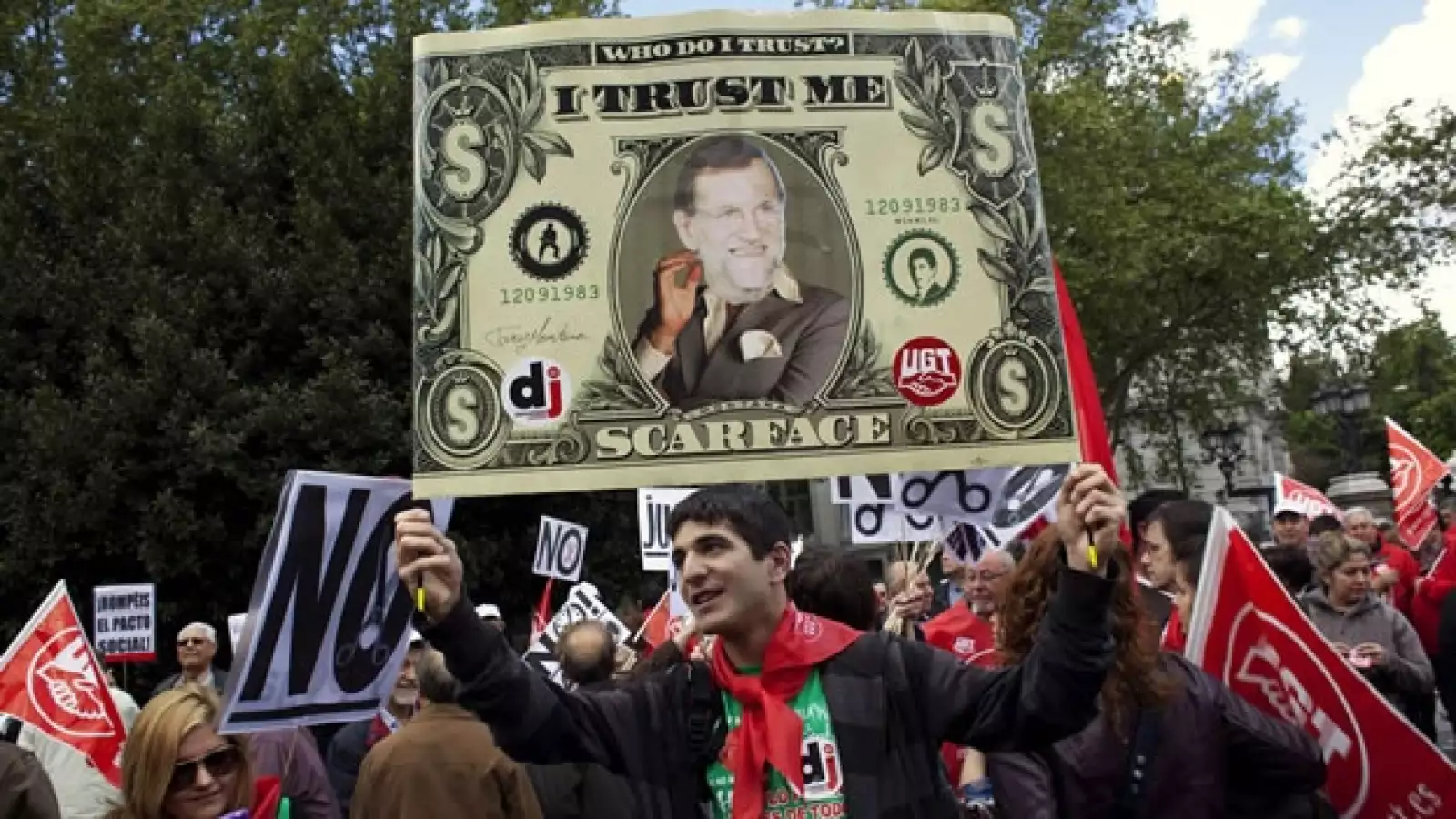 joven porta un dolar con el rostro de rajoy