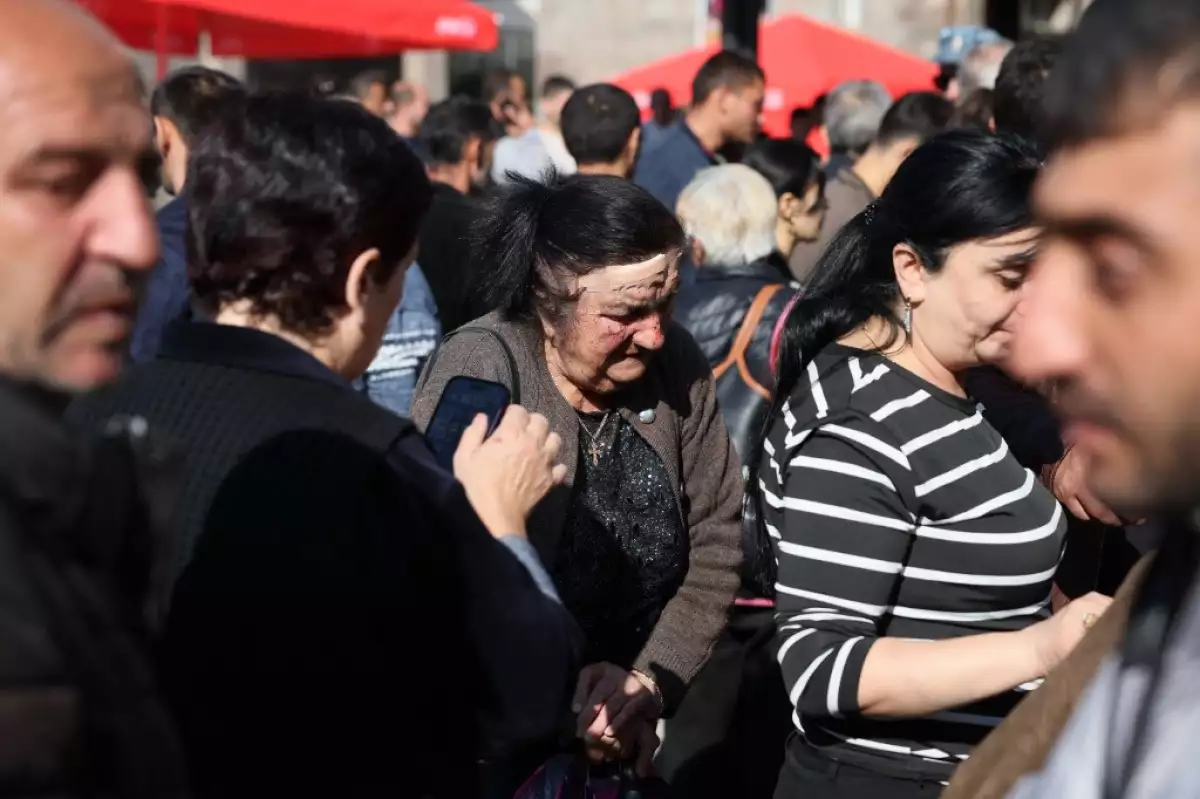 Los refugiados, incluida una anciana con una herida en la cabeza que dijo que tuvo un accidente automovilístico cuando su familia huía de Nagorno-Karabaj, esperan para pasar cerca de un centro de registro de la Cruz Roja en Goris, el 27 de septiembre de 2023. Armenia, el 26 de septiembre de 2023, dijo que hasta ahora han llegado 28,120 refugiados de Nagorno-Karabaj, un enclave separatista de mayoría de etnia armenia derrotado en una ofensiva relámpago por Azerbaiyán la semana pasada.