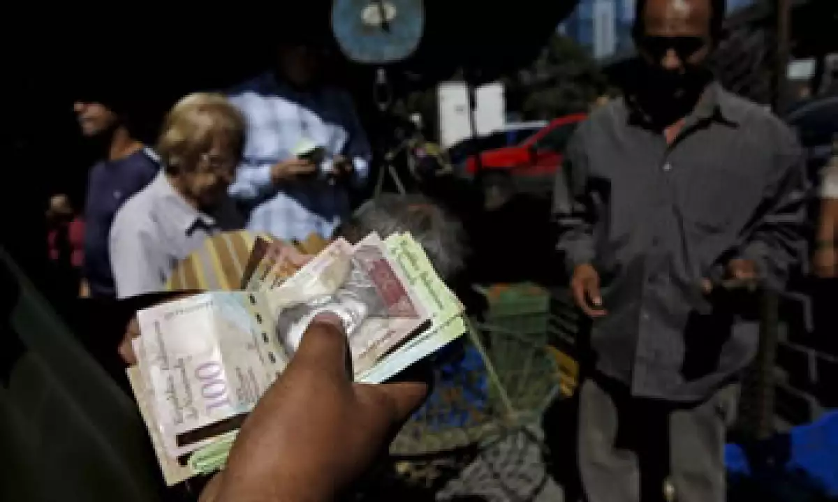 Un hombre cuenta bolívares en un mercado de vegetales en Caracas, capital de Venezuela. (Foto: Reuters )