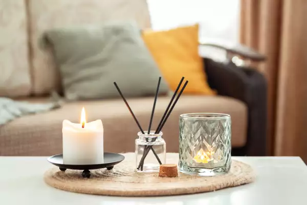 Velas perfumadas y palitos de incienso aromático en la mesa de la sala de estar. Aromaterapia, fragancia para el hogar. Concepto de relajación en el hogar y anti-estrés.