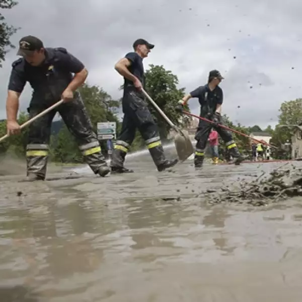 miembros del servicios de emergencias limpian las calles de una ciudad austriaca
