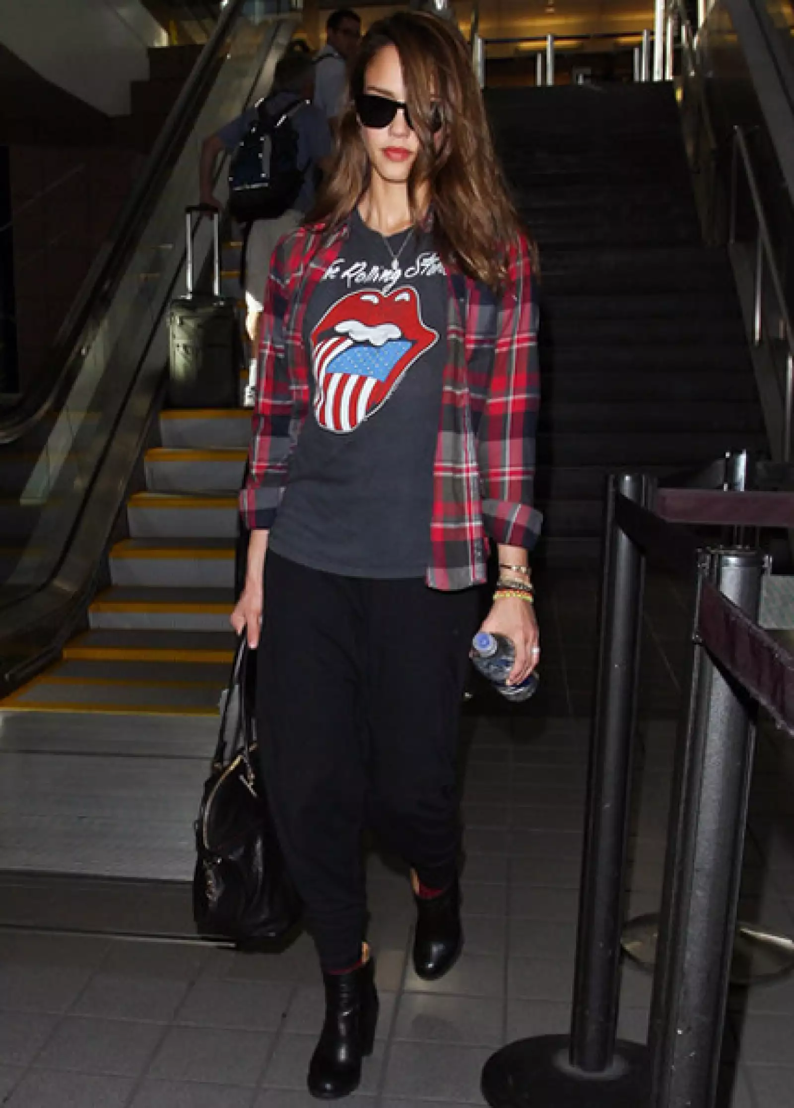 Para viajar cómoda Jessica Alaba combina una playera de los Rolling Stones con una camisa de franela a cuadros.