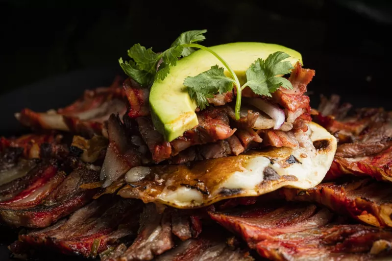 Taco de pastor servido sobre más carne, en el restaurante Animal St. Regis de Grupo Costeño.