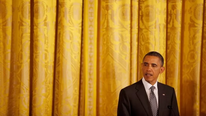 obama delante de una cortina amarilla