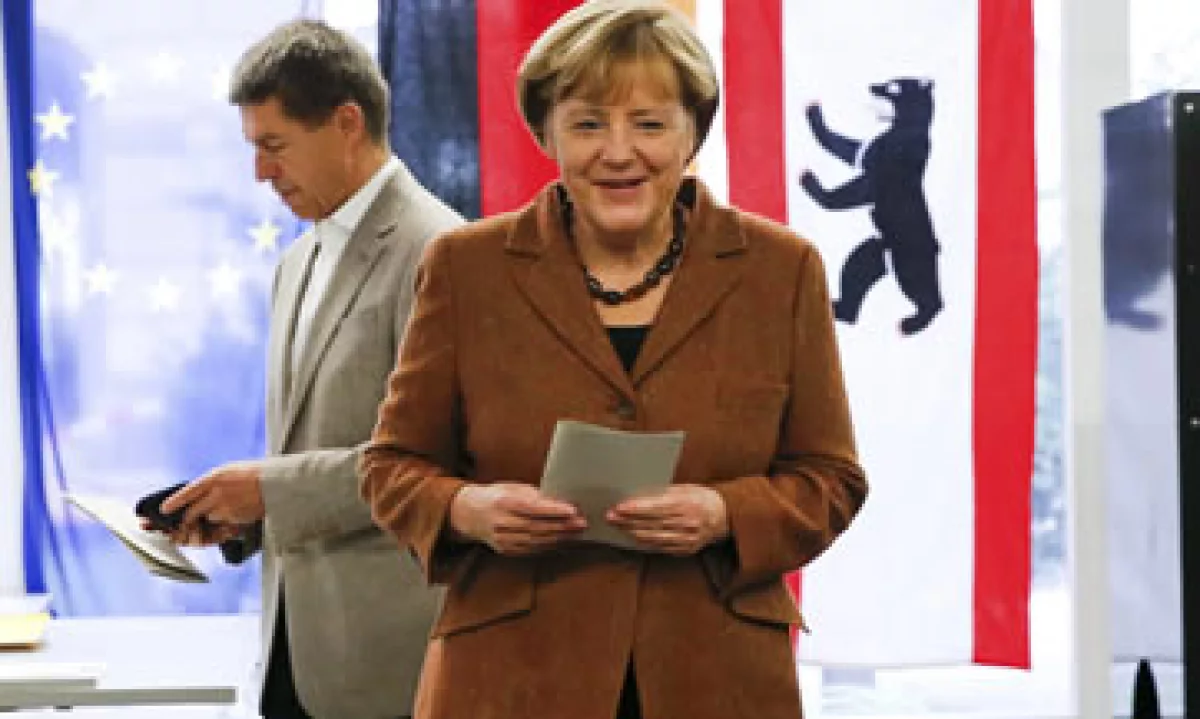 Merkel al depositar su voto este domingo (atrás su esposo) (Foto: Reuters)