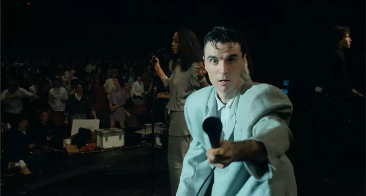 Foto de una escena del documental Stop Making Sense donde se ve a David Byrne de joven en un concierto de los Talking Heads.