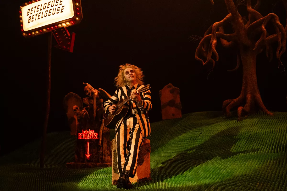 Foto de la película de Beetlejuice con el personaje de Michael Keaton tocando la guitarra dentro de una maqueta.