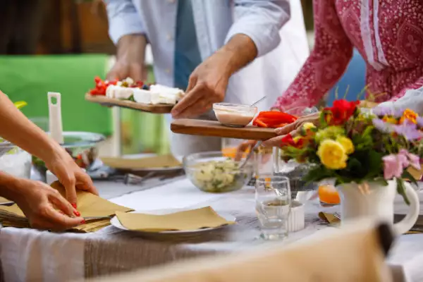 Unrecognizable senior couple serving a delicious charcuterie board for dinner in the back yard