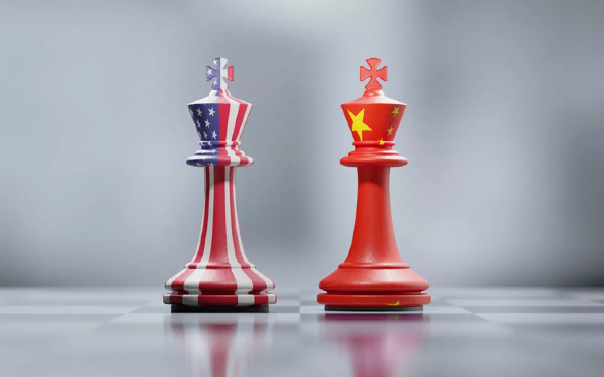 Two King Chess Pieces Textured With American And Chinese Flags On Black And White Chessboard