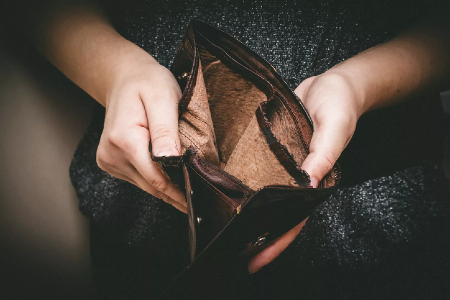 Old empty wallet in the hands .Vintage empty purse in hands of women . Poverty concept, Retirement. Special toning