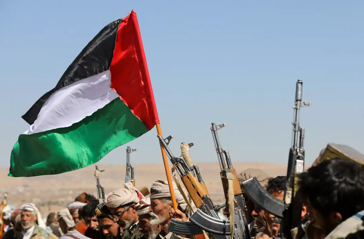 Los partidarios tribales de los hutíes de Yemen agitan una bandera palestina y sostienen sus armas de fuego durante una protesta por los recientes ataques liderados por Estados Unidos contra objetivos hutíes, cerca de Sanaa, Yemen, el 14 de enero de 2024.