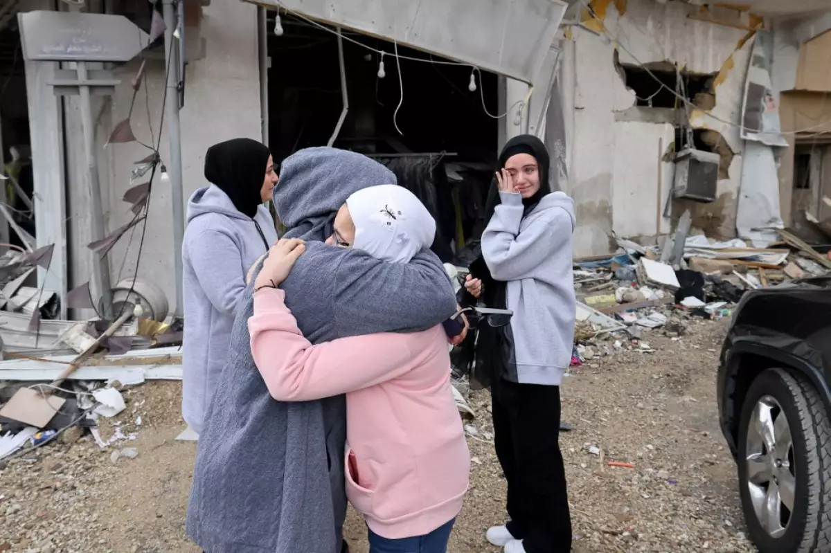 Las mujeres se saludan mientras las personas desplazadas regresan a sus hogares en el sur del Líbano después de que entrara en vigor un alto el fuego entre Israel y Hezbolá, el 27 de noviembre de 2024, en la ciudad sureña de Qana.  