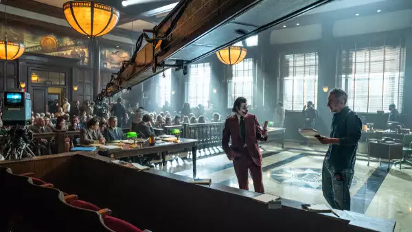 Foto de la grabación de Joker 2, con una cámara de cine arriba y Joaquin Phoenix como el Joker al centro y el director Todd Phillips a la derecha.