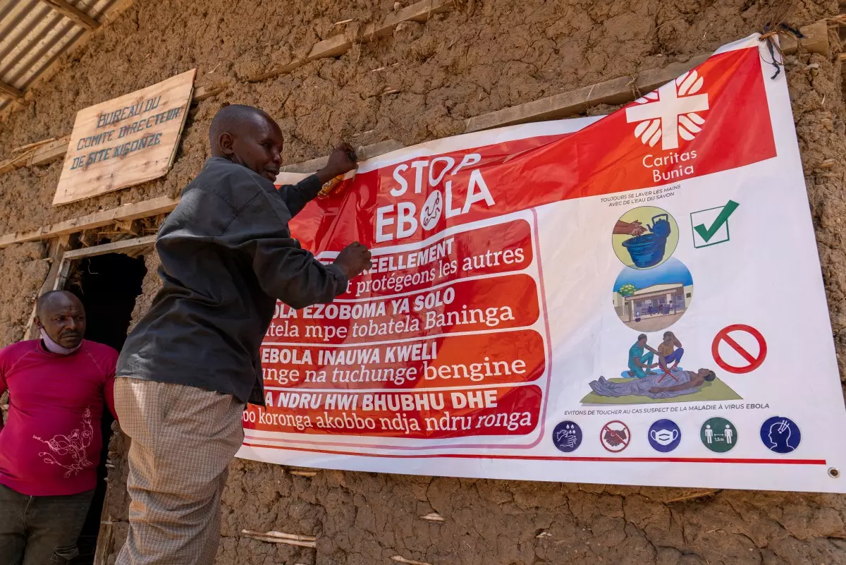 Un hombre cuelga una pancarta de concienciación sobre el ébola en el campamento de Kigonze en Bunia, en el este de la República Democrática del Congo, el 28 de mayo de 2026. Un brote de fiebre hemorrágica del Ébola se está extendiendo rápidamente en el este de la República Democrática del Congo, uno de los países más pobres del mundo.