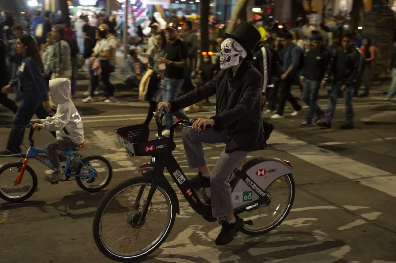 Ciclistas circulan con personas caminando durante el Paseo Nocturno de Dia de Muertos 2026