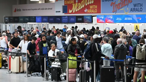 Unos pasajeros aguardan con su equipaje mientras hacen cola para facturar en la Terminal Sur del aeropuerto de Londres-Gatwick, cerca de Crawley (sur de Inglaterra), el 9 de septiembre de 2026, tras una segunda jornada de graves perturbaciones causadas por un problema en los sistemas de control de tráfico aéreo de NATS.