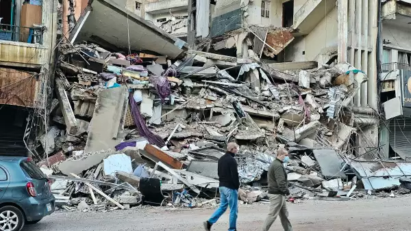 Esta foto tomada el 9 de abril de 2026, personas caminando en el lugar de los ataques aéreos israelíes del día anterior que atacaron el sur del barrio al-Shiyah de Beirut. El ejército israelí dijo que atacó a un comandante de Hezbolá en Beirut el 8 de abril, después de que los medios estatales libaneses informaran que Israel había atacado un barrio residencial en la capital.