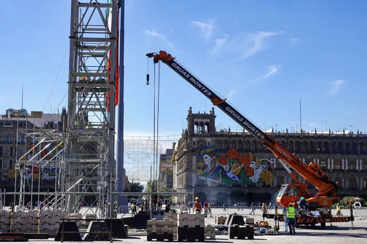Grúas trabajando en la instalación en el Zócalo para el Día de Muertos.