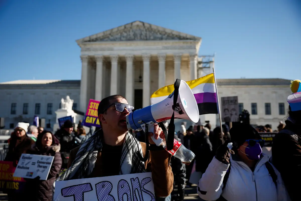 Derek Torstenson usa un megáfono mientras sostiene un cartel en una manifestación, mientras la Corte Suprema de los Estados Unidos escucha argumentos sobre una apelación de la administración del presidente estadounidense Joe Biden de la decisión de un tribunal inferior que defiende una prohibición respaldada por los republicanos en Tennessee sobre la atención médica de afirmación de género para menores transgénero, fuera del tribunal en Washington, EE. UU., 4 de diciembre de 2024