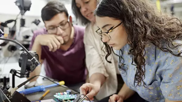 College instructor assisting electrical engineering students