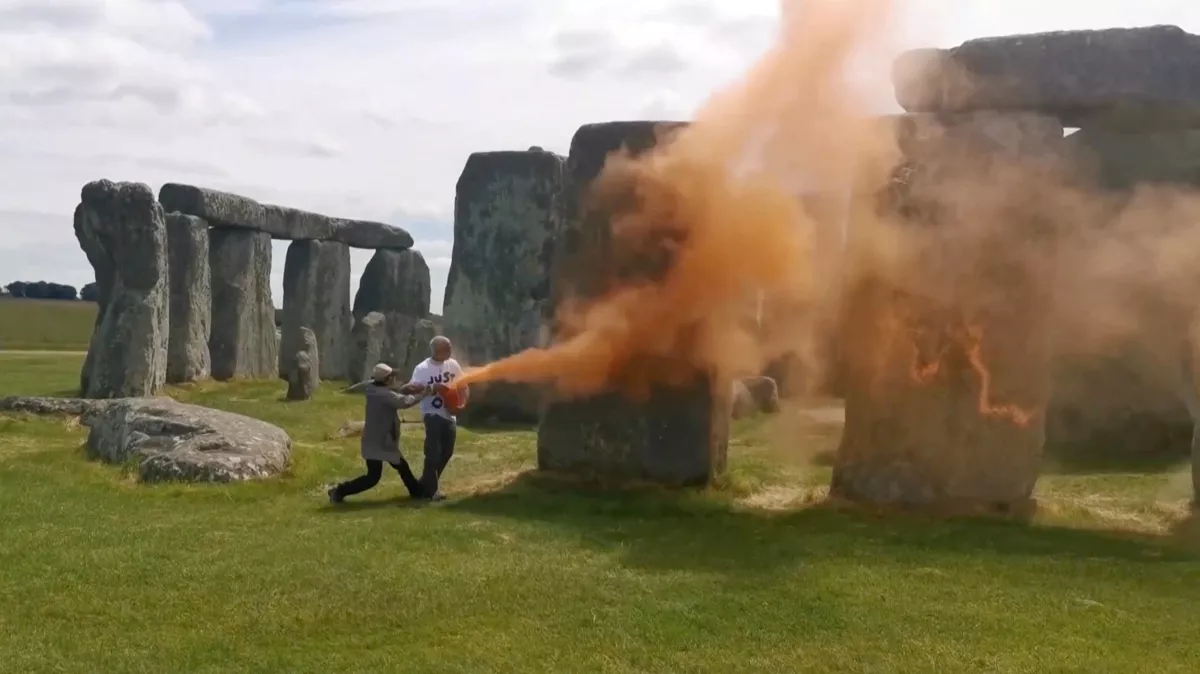 Manifestantes ambientalistas rocían Stonehenge con pintura en polvo naranja, en Wiltshire, Gran Bretaña, el 19 de junio de 2024, en esta captura de pantalla tomada de un video.
