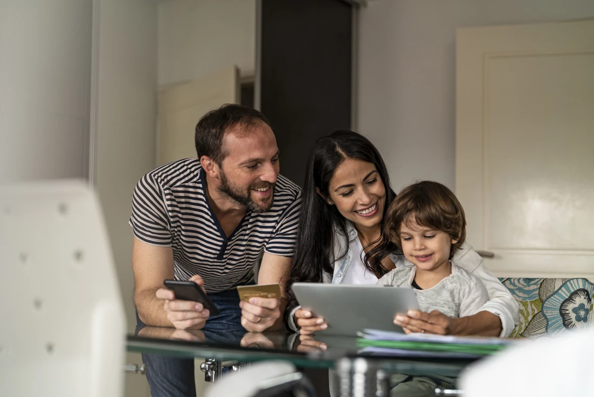 Familia en casa mientras hacen compras en línea, usando una tablet