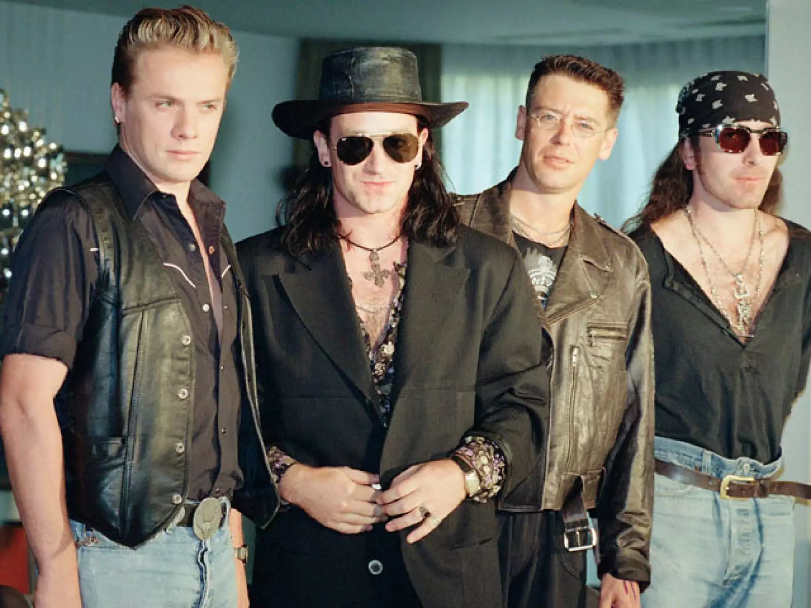 Aunque al inicio de su carrera Bono no usaba lentes, para los 80 ya lo veíamos continuamente con este accesorio. Aquí en 1989 junto al resto del grupo: Larry, Adam y The Edge.