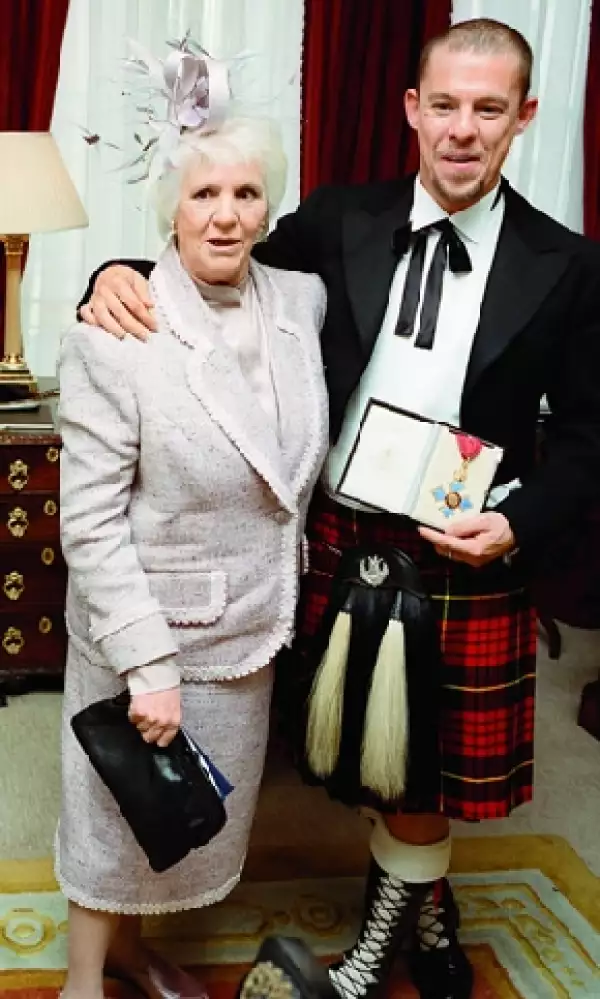 El diseñador junto a su madre Jocelyn, al recibir la medalla de la Orden del Imperio Británico en 2003.