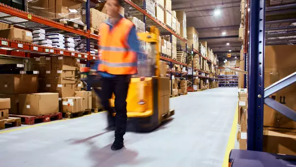 Warehouse, worker with a forklift in motion blur.