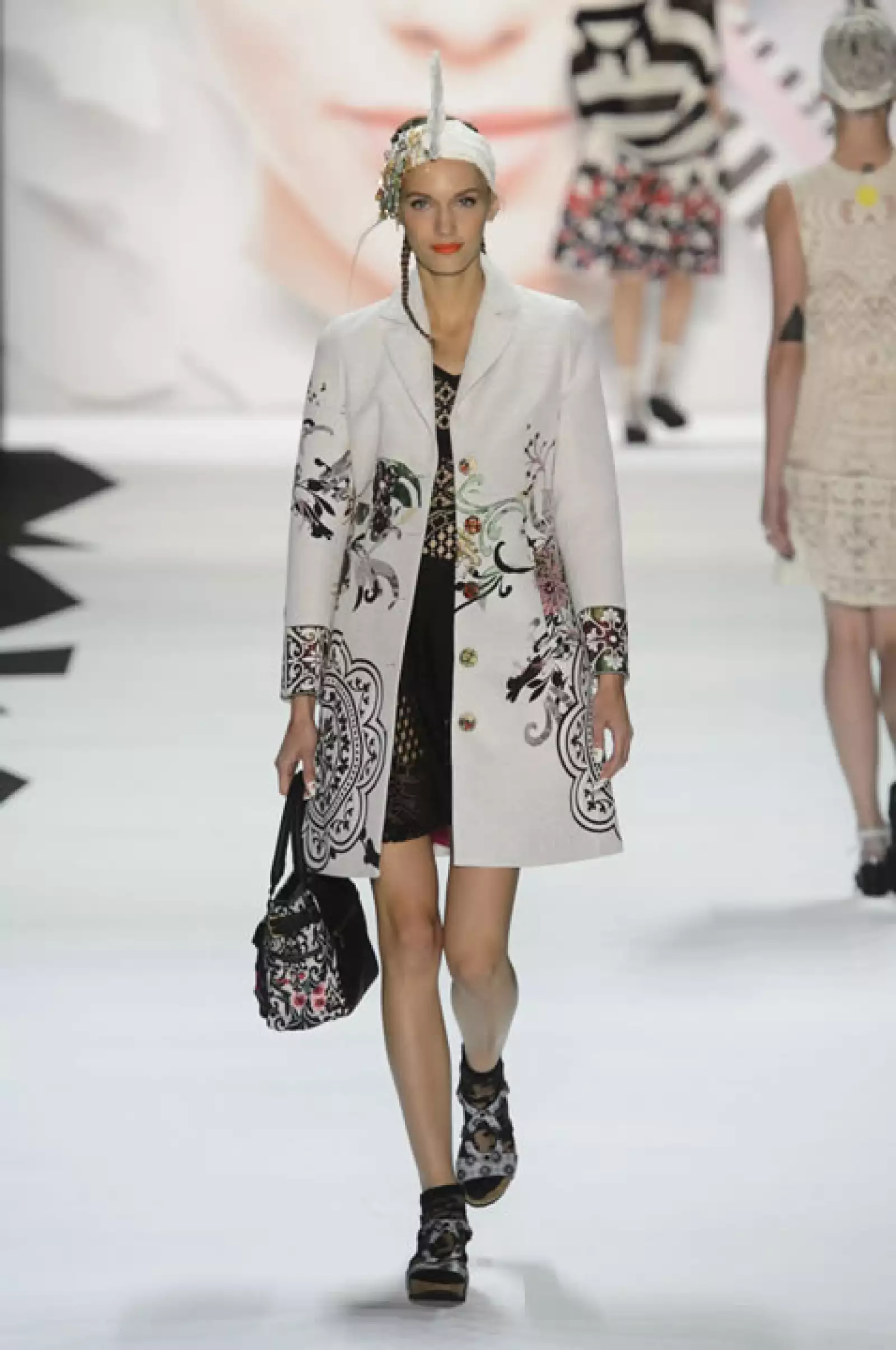 Trenchcoat de jacquard, vestido negro con sandalias.