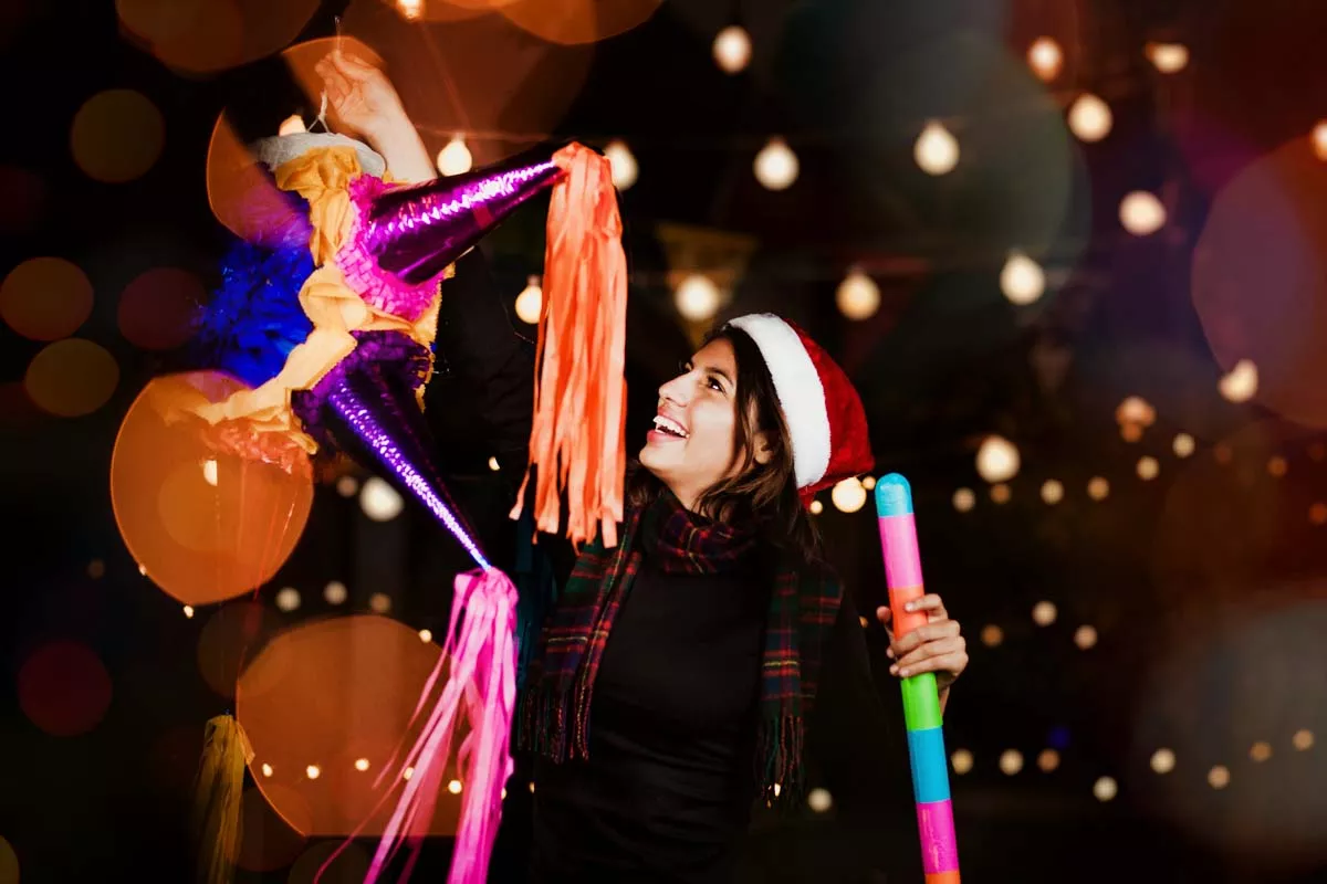 Por qué se celebran las posadas (Mujer sostiene una piñata)