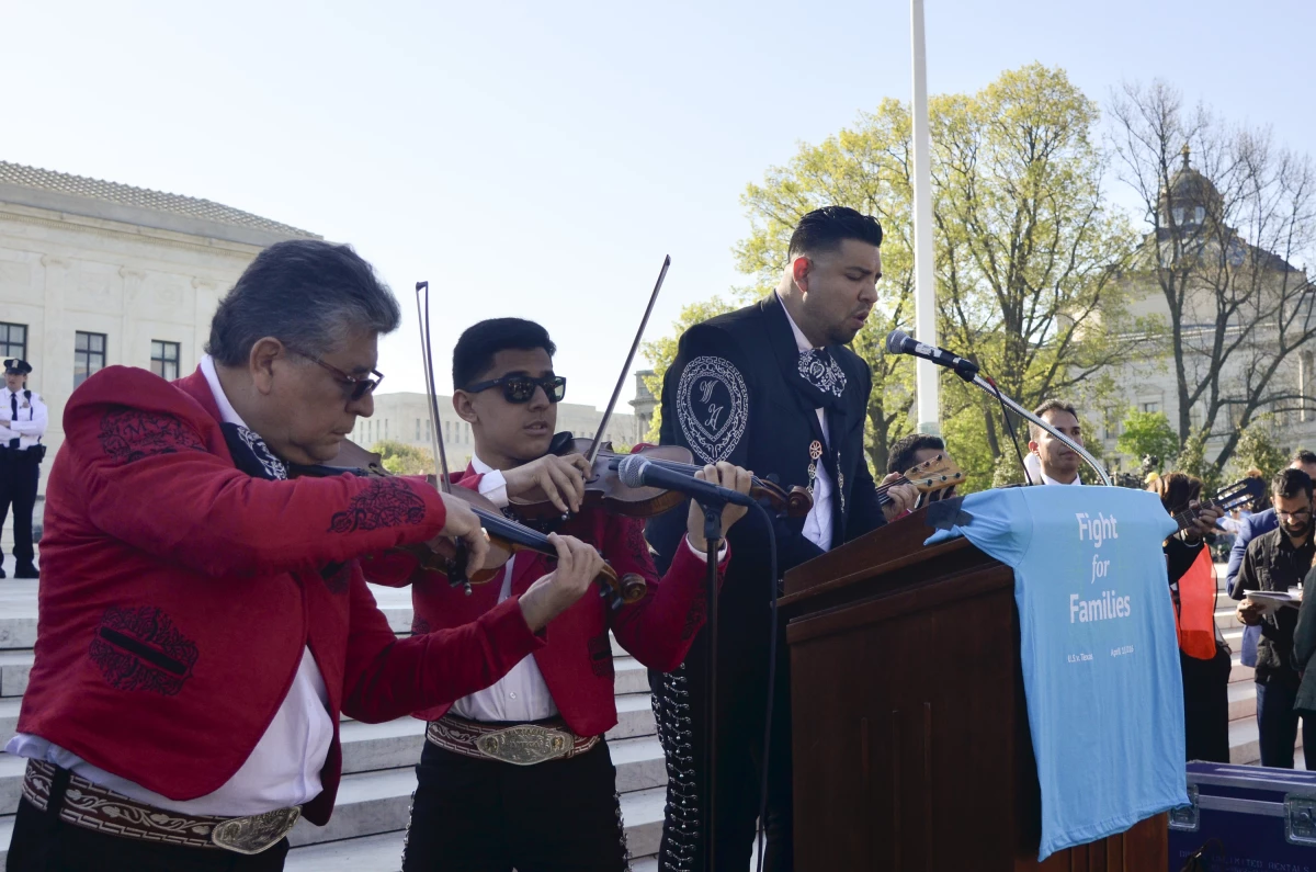 Jesús Ramos (derecha) entona el himno estadounidense frente a la Corte Suprema este lunes como parte de una manifestación para pedir leyes a favor de los inmigrantes.