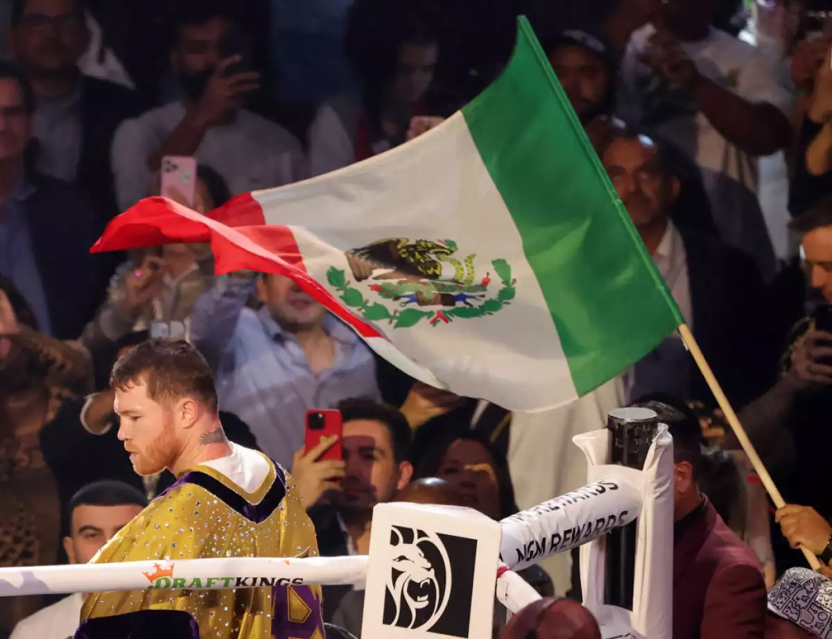 Foto de archivo de Saúl Canelo Álvarez en el ring con la bandera de México ondeando sobre su cabeza
